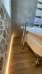 Eclairage élégant au sol de la salle de bain avec baignoire en pattes de lions