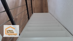 Un escalier repeint en blanc et sécurisé mène vers un espace de vie lumineux, où le sol PVC effet bois offre chaleur, confort et modernité.