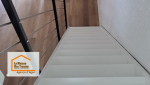 Un escalier repeint en blanc et sécurisé mène vers un espace de vie lumineux, où le sol PVC effet bois offre chaleur, confort et modernité.