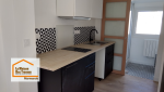 Rénovation complète d’une cuisine pour la location à Marmande : mobilier noir et blanc, plan de travail effet bois et aménagement optimisé par La Maison Des Travaux.