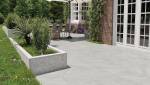 terrasse en carrelage extérieur grand format gris avec espace repas et jardin aménagé