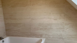 Détail des revêtements muraux en travertin dans la salle de bain rénovée