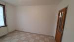 Ancienne chambre avec carrelage et porte vitrée avant les travaux d'agrandissement.