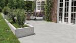 terrasse en carrelage extérieur grand format gris avec espace repas et jardin aménagé