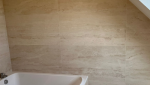 Détail des revêtements muraux en travertin dans la salle de bain rénovée