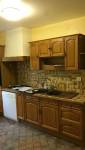Cuisine ancienne avec meubles en bois et carrelage daté avant rénovation complète