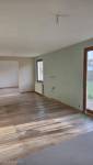 Salon rénové avec parquet stratifié et ouverture structurelle sur salle de jeux à Carvin