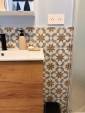 Détail crédence en mosaïque façon zellige et plan vasque blanc.