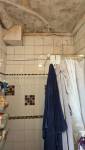 Salle de bains avant rénovation avec meuble vasque et carrelage ancien