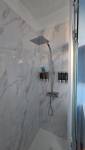Douche à l’italienne rénovée avec receveur extra-plat et revêtement mural contemporain