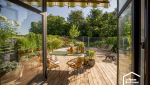Terrasse en bois avec pergola et espace repas, exemple d’aménagement extérieur à Agen conçu pour profiter pleinement du jardin tout au long de l’été.