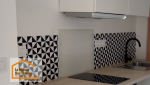 Pose d’une crédence graphique noir et blanc dans une cuisine rénovée à Quimper, créant une ambiance moderne et personnalisée.