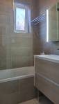 Zoom sur le carrelage couleur sable avec sa frise effet relief et le nouveau mobilier en bois clair à Courrières