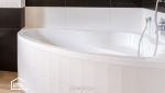 Détail d’une baignoire d’angle avec robinetterie moderne dans une salle de bain rénovée à Agen, Lot-et-Garonne.