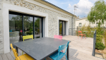 Vue extérieure de la maison à Sainte-Bazeille avec terrasse en bois, dans le cadre d’un projet de rénovation accompagné par La Maison Des Travaux Marmande.