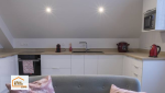 Cuisine moderne réalisée à Quimper avec mobilier blanc, plan de travail effet bois et implantation optimisée. Une rénovation intérieure accompagnée par La Maison Des Travaux Quimper.