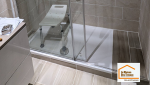 Vue détaillée de la douche sécurisée avec barre d’appui, mitigeur thermostatique et carrelage effet pierre dans une salle de bain rénovée à Aix-en-Provence.