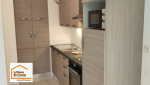 Aménagement d’une cuisine contemporaine avec colonnes de rangement et meubles toute hauteur permettant de maximiser l’espace disponible dans un appartement près de Venelles.
