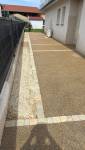 Cour en béton désactivé à Saint-Cassien avec bordures en pavés et finition en gravier.
