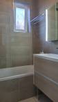 Zoom sur le carrelage couleur sable avec sa frise effet relief et le nouveau mobilier en bois clair à Courrières