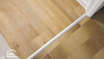 Détail des finitions du sol PVC imitation bois, une solution durable pour moderniser une salle de bains près d'Aix-en-Provence.