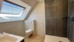 Douche contemporaine avec paroi vitrée dans une salle de bain sous combles rénovée. 