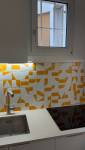 Rénovation cuisine Paris, crédence en carreaux graphiques orange et blanc, vue d'ensemble
