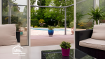 Aménagement intérieur d’une véranda à Plomelin avec salon confortable et grandes surfaces vitrées pour créer une véritable pièce de vie supplémentaire.
