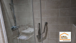 Douche sécurisée avec receveur extra-plat antidérapant, siège de douche et parois vitrées, réalisée lors d’une rénovation de salle de bain à Aix-en-Provence.