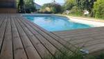 La nouvelle terrasse en bois offre un cadre chaleureux et confortable autour de la piscine.