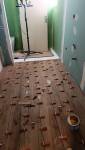 Pose du carrelage effet bois dans une salle de bain adaptée au maintien à domicile à Charancieu.