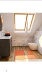 Modélisation 3D d'une salle de bain rénovée sous combles avec meuble vasque, WC suspendu et carrelage effet marbre.