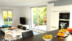 Aménagement d'une cuisine contemporaine près de Venelles avec mobilier blanc, plan de travail noir et électroménager intégré, réalisé dans le cadre d'une rénovation intérieure complète.