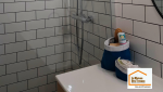Vue d’ensemble d’une salle de bain moderne rénovée près du Tholonet avec douche à l’italienne, meuble vasque suspendu et carrelage métro blanc.