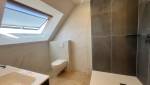 Douche contemporaine avec paroi vitrée dans une salle de bain sous combles rénovée. 