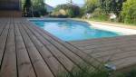 La nouvelle terrasse en bois offre un cadre chaleureux et confortable autour de la piscine.