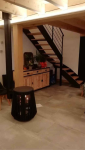 Installation d'un poêle à bois contemporain dans la pièce de vie d'une maison ancienne en pisé à Voiron.