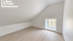 Pièce sous toiture avec plancher bois ancien et petite fenêtre dans une maison à Arzon