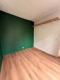 Espace nuit vert sapin avec étagère en chêne, studio rénové Paris 19