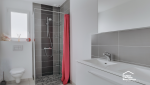 Rénovation d’une salle de bain à Aix-en-Provence avec douche ouverte, carrelage gris, meuble vasque et WC suspendu.