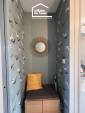 Coin assise avec rangement intégré et papier peint dans une entrée rénovée à Damgan