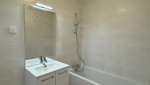 Salle de bains rénovée avec baignoire et meuble vasque