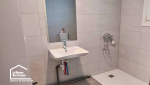Vue d’ensemble de la salle de bain adaptée à Castillonnès, avec douche accessible, WC et circulation facilitée dans la pièce.