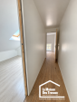 Couloir rénové à l'étage d'une maison ancienne à Arzon, avec murs blancs et plancher bois