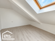 Pièce sous combles rénovée avec fenêtre de toit et sol clair dans une maison à Arzon