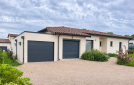 Garage en modules béton avec toit plat et porte anthracite, attenant à une maison à L’Isle-Jourdain. 