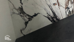 Pose de faïence grand format effet marbre pour une salle de bain moderne rénovée à Quimper par des artisans locaux.