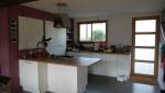 Aménagement cuisine vu depuis espace repas sur baie vitrée - Trilport - 