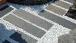 dalles en ardoise sur gravier blanc pour permettre un passage facilité aux poussettes