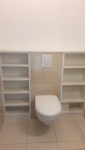 Toilette entouré d'étagères de rangement 